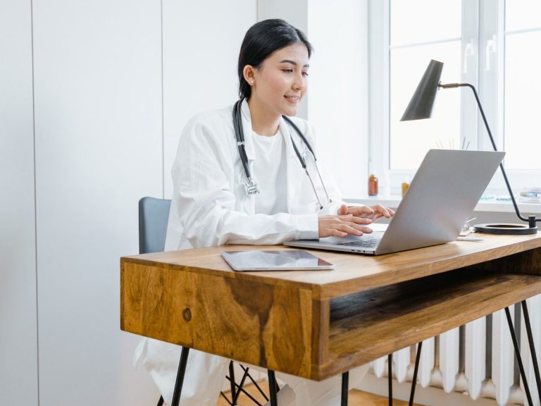 Docteur étudiant sa formation à distance depuis son bureau et son ordinateur