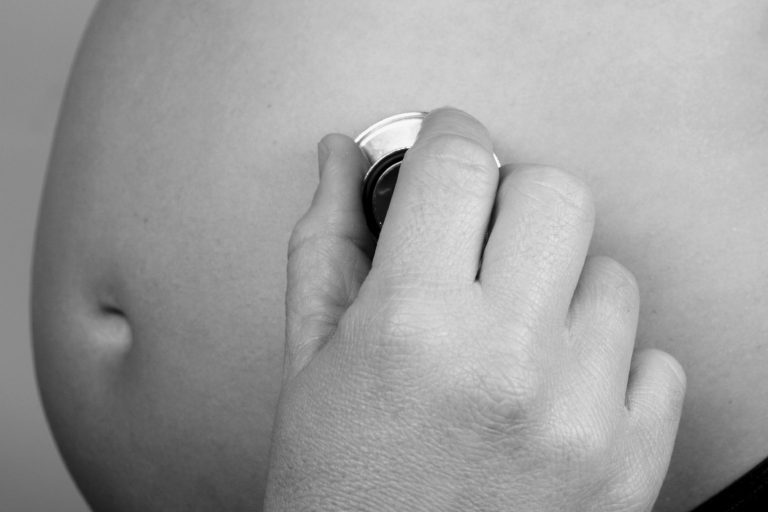 Sage-femme touchant le ventre d'une femme enceinte